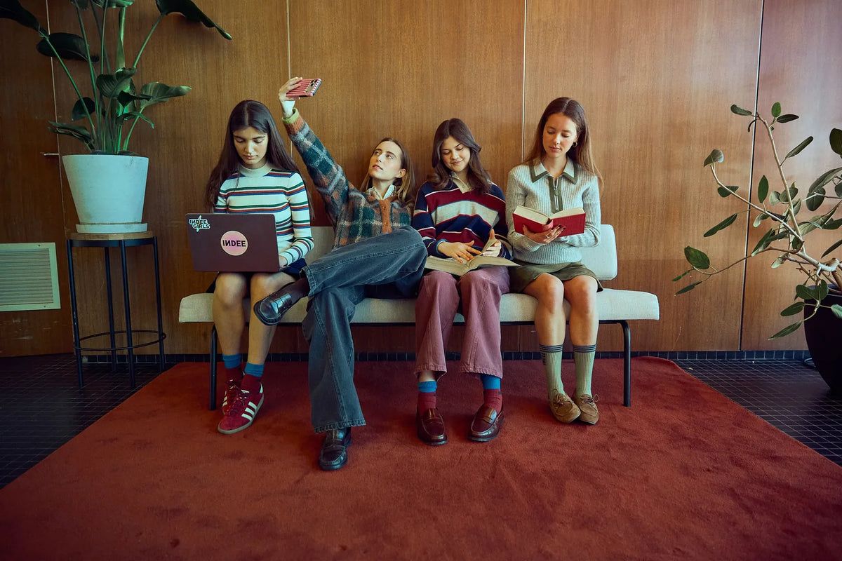 Four women in Indee clothing sitting on a bench