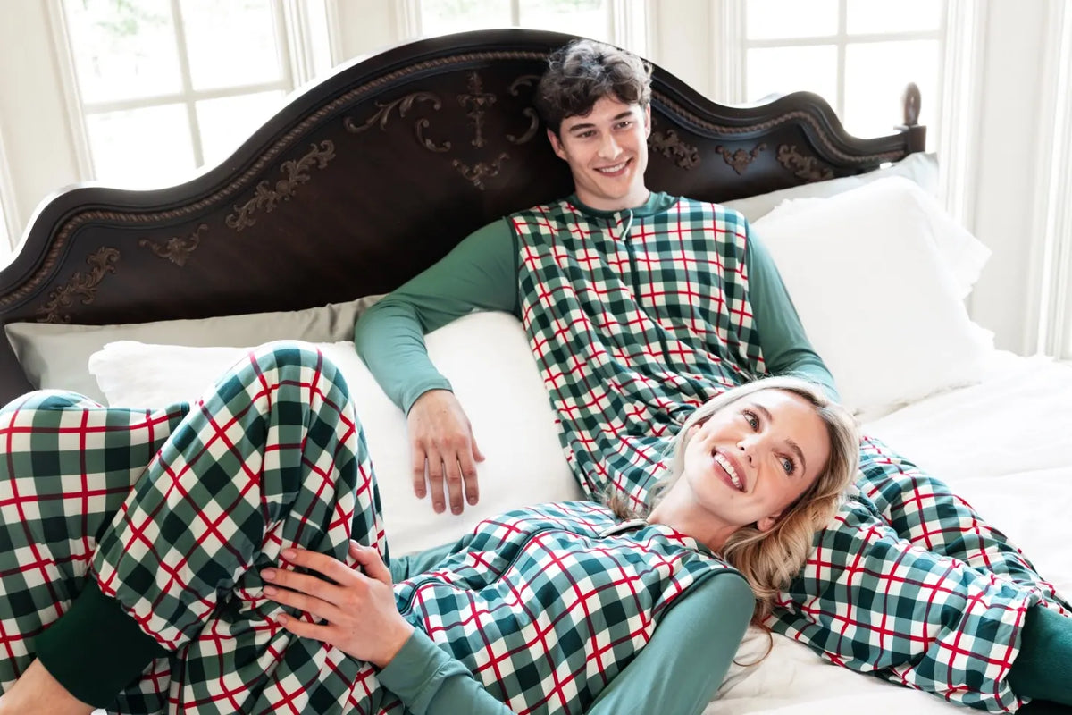 Couple in Kyte Living plaid pyjamas on a bed